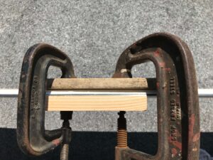 スノーボードのトップシートがはがれた部分を万力で挟んで修理する
